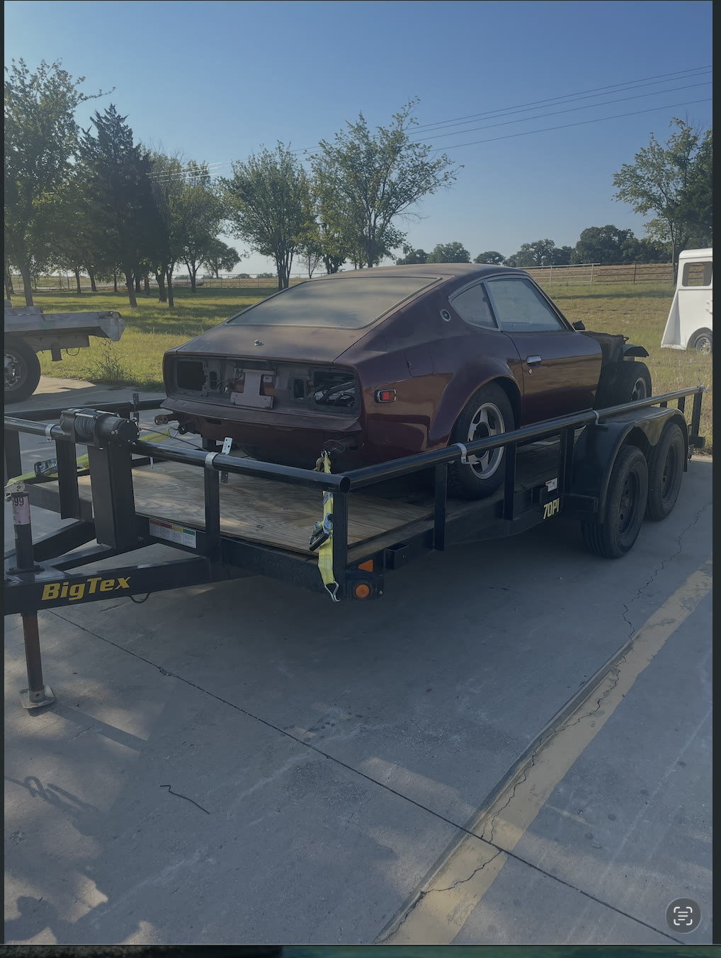 Datsun Z on a trailer being transported for restoration